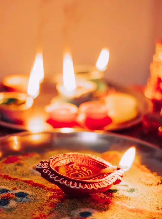 Oil lamps (diyas) lit on rangoli for a puja