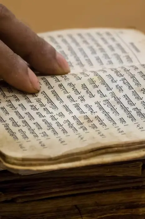 An aged Sanskrit manuscript open to its verses