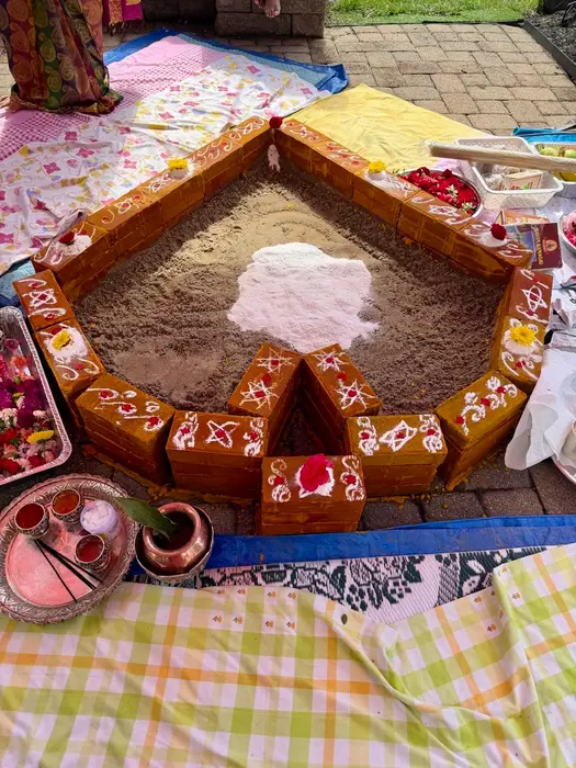 A turmeric-brick homa kunda decorated with white kolam